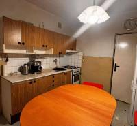 A kitchen in a 2-room apartment with an electric oven and a drawer unit with a wooden decor.