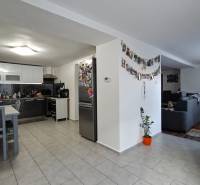 Kitchen with living room in a family house, wooden decor flooring, wall decorations.