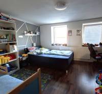 Children's room in a family house with beds, toys, and a wooden decor floor.