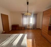 The bedroom dominates in the family house with a wooden decor floor and a large wardrobe.