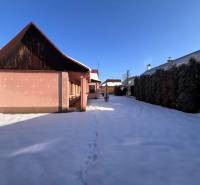 A family house in a snowy garden in Stará Bystrica with a blue sky.
