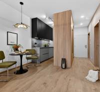 Kitchen corner with dining table in a 2-room apartment, floor with wooden decor.