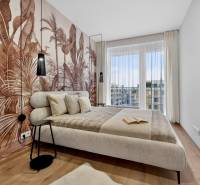 Bedroom in a 2-room apartment with a wooden decor floor and exotic wallpaper on the wall.