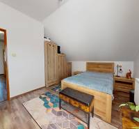 A bedroom in a family house with a wooden decor floor and wooden furniture.