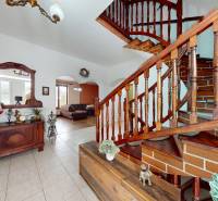 Interior of a family house with a wooden staircase, a mirror, and a heron decoration.