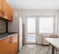 Kitchen corner in offices with ceramic tiles and a white refrigerator.