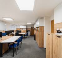 Offices with desks, computers, and cabinets, floor with wood decor, bright lighting.