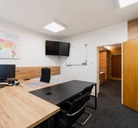 Offices with a map on the wall, a monitor, and a wooden decor floor.