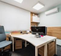 Offices with a computer, chair, and wood decor on the wall and floor.