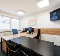 Offices with a desk, chairs, a map, and a television, complemented by a floor with a wooden decor.