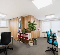 Offices with blue chairs, carpeted floors, and cabinets with wood decor.