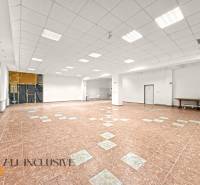 Spacious commercial premises with tiled floors and white walls, suitable for various uses.