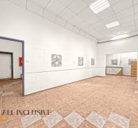 Commercial premises with a tiled floor and high white ceiling.