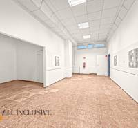 Commercial spaces with wood-patterned flooring and white walls.