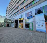 The facade of the building with glass offices in Poprad on a paved parking lot.