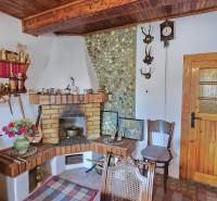Interior of a family house with a rustic fireplace, decorative furniture, and wooden decorations.