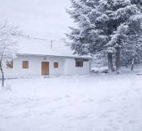 A snow-covered family house on Stará Huta Street 84, Stará Huta, surrounded by trees.