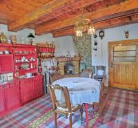 The interior of a family house with a wooden ceiling, a red cabinet, and a dining table.