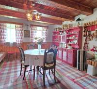 Traditional room in a family house with wooden ceilings, colorful furniture, and decorations.