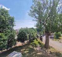 A parking lot surrounded by trees in Poprad, with a view from a 2-room apartment.