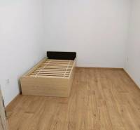 A room in a 3-room apartment with a bed and a floor with a wooden decor.