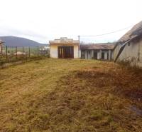 A grassy plot near a family house in Nová Bašta with a view of the surrounding countryside.