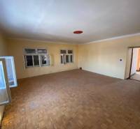 Empty room with wood-patterned flooring and windows in a family house.