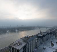 Winter panorama of Pribinova Street in Bratislava, snow-covered roofs and the Danube River.