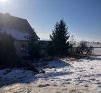A family house in Rudník on Rudník Street with courtyards covered in winter snow.