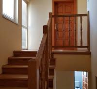 Interior of a family house with a wooden staircase and doors.