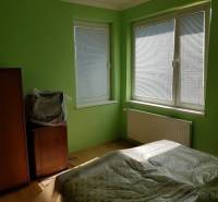 Green interior with a bed, cabinet, television, and plastic covering in a family house.
