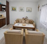 Family house with a cozy living area, kitchen, decorative paintings, and wooden decor flooring.