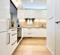 A kitchen in a 3-room apartment with white cabinets and a wooden decor floor.