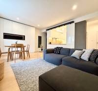 Living room in a 3-room apartment with a wooden decor floor and a comfortable couch.