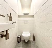 A toilet with ceramic tiles and chrome accessories in a 3-room apartment.