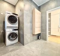 Washing machine with dryer, gray tiles, bathroom in a 3-room apartment.