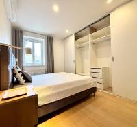 A bedroom in a 3-room apartment with a large built-in wardrobe and a floor with a wooden decor.