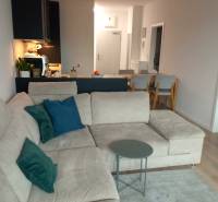 Living room with a sofa and a table in a two-room apartment with a wooden decor floor.