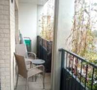 Balcony of a 2-room apartment with metal railings and outdoor seating.