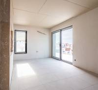 A room under construction with tiles and large windows in a 3-room apartment.