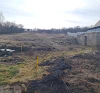 Plots - housing on Poľná Street in Banka, with grassy and overgrown areas.