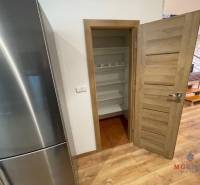 The kitchen in the 3-room apartment includes a refrigerator, a pantry, and a floor with a wooden decor.