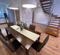 Dining room in a 3-room apartment with a wood-patterned floor and a staircase.