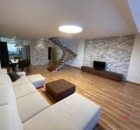 Living room in a 3-room apartment with a wooden decor floor and comfortable seating.