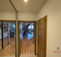 Interior of a 3-room apartment with a wooden decor floor and a staircase.