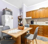 A kitchen in a family house with wooden cabinets, a table and chairs, appliances on the countertop.