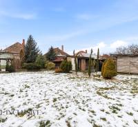 A snowy garden of a family house on Čečínská Potôň in Orechová Potôň with wooden shelters.