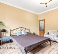 Bedroom in a family house with a bed, sofa, and wooden decor flooring.