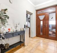 Entrance hall in a family house with wooden doors and decorative furniture on the floor.