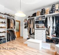 Wardrobe with clothes and shoes, floor with wooden decor, family house.